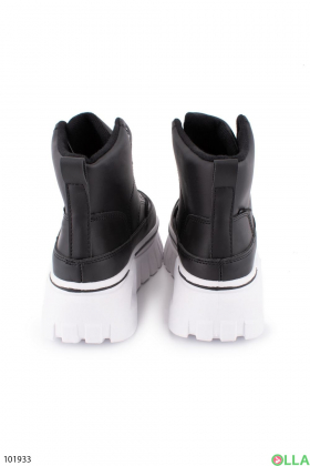 Жіночі чорні черевики з білою підошвою.