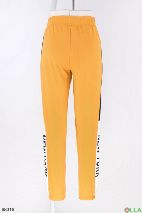 Жіночі помаранчеві спортивні штани з написом